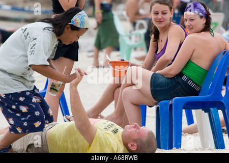 Betrunkene Menschen entspannen bei Sonnenaufgang nach der Full Moon Party Stockfoto