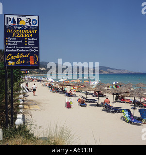Blick entlang Sands mit strohgedeckten Sonne Schirme und Sonnenliegen am Strand Alikes Ostküste Zakynthos Insel der griechischen Inseln Griechenland Stockfoto