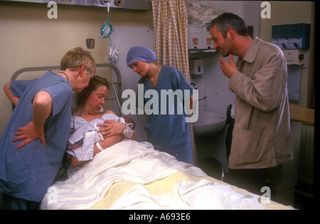 Hebamme Vater und Großmutter bewundern neues Baby geboren Stockfoto