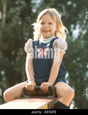 kleine glückliche Mädchen spielen auf Wippe Stockfoto