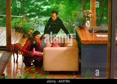 EINE JUNGE FAMILIE IN EIN MODERNES HAUS MIT GROßEN GLAS SCHIEBE-FENSTER UK Stockfoto