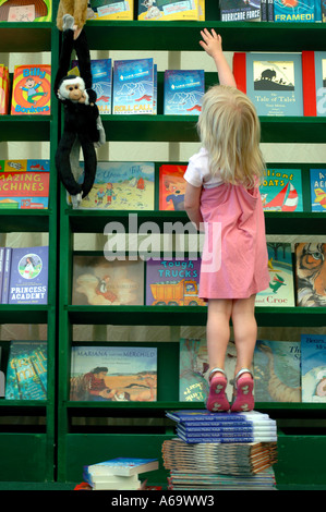 EIN JUNGES MÄDCHEN ERREICHT FÜR EIN BUCH IN CHELTENHAM LITERARISCHE FESTIVAL 2005 Stockfoto