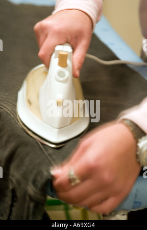 Ausschneiden, Nahaufnahme Bild von Frauenhand Bügeln. Langsame Verschlusszeit für dynamischen Bild mit Motion blur. Stockfoto