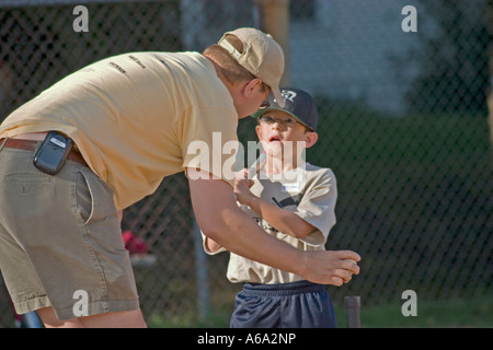 T-Ball Teig immer Ratschläge von Trainer Alter 7 und 32. Groveland Schule Feld St Paul Minnesota USA Stockfoto