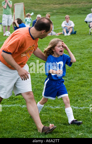 Coachen Sie beruhigend weinenden Fußballspieler Alter 35 und 6 nach einer Sportverletzung. Carondelet Feld von Expo Schule St. Paul Minnesota USA Stockfoto