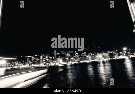 Hong Kong Hafen in der Nacht auf der Fähre Blick in Honk Kong Lichter der Stadt reflektiert in Bewegung des atmosphärischen Wassers Stockfoto