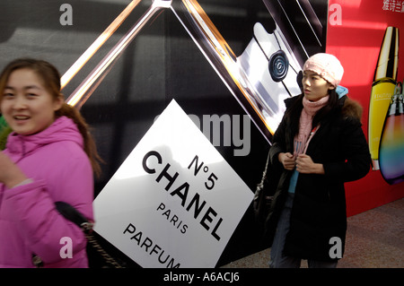 Zwei Damen gehen vorbei an einer Plakatwand mit Paris Chanel Nr. 5 in Peking 25. Dezember 2005 Stockfoto