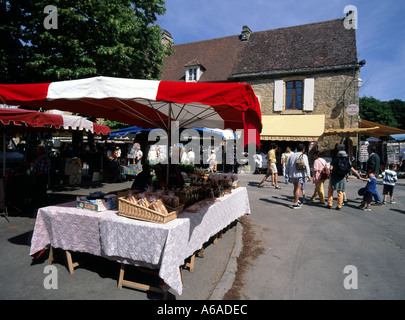 Domme Stadtplatz Straßenszene Touristen und Einheimische an farbenfrohen französischen Marktständen im Département Dordogne Nouvelle-Aquitaine im Südwesten Frankreichs Stockfoto