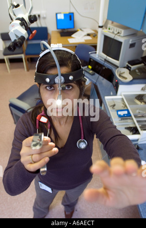 Eine asiatische Ärztin streckt mit der Hand, während leichte UK tragen ein Spezialist-Kopf montiert werden. Stockfoto