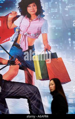 Eine Frau geht vorbei an einem riesigen Plakat mit Einkaufen in China modernes Leben in Peking 2006-01-16 Stockfoto