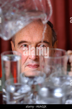 EIN PENSIONIERTER MANN, GIEßEN EIN GLAS WASSER UK Stockfoto