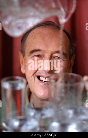 EIN PENSIONIERTER MANN, GIEßEN EIN GLAS WASSER UK Stockfoto