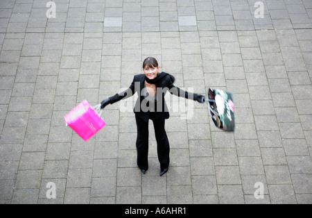 Junge Frau einkaufen hält ihr zwei Einkaufstüten einkaufen Stockfoto