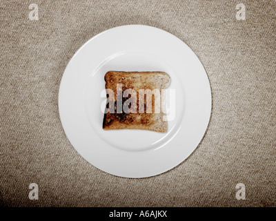 Scheibe von verbranntem Toast auf weißen Teller Stockfoto