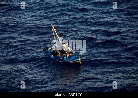 Kleines Boot voller Einwanderer aus Nordafrika in mediterranen Freiwasser bitten um Hilfe, Polizei-Hubschrauber Stockfoto