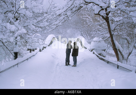 New York City Central Park zwei Menschen auf Gapstow Brücke in einem Schneesturm Stockfoto