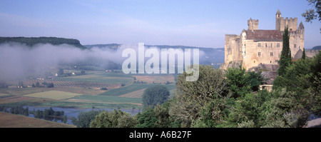 Schloss Château de Beynac in der Sonne auf Felsenklippe oberhalb des Flusses Dordogne gebaut, blockiert Nebel die Sonne von der Ackerlandschaft Nouvelle-Aquitaine Frankreich Stockfoto