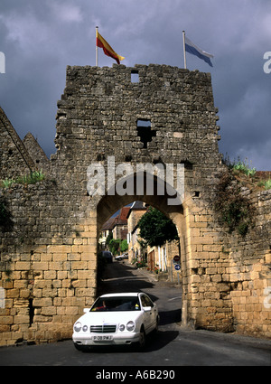 Domme Dordogne Porte Del Bos Car & Stone Gateway Bogenarchiv Straßenszene enge mittelalterliche Straßenflaggen an der historischen Stadtmauer Nouvelle Aquitaine Frankreich Stockfoto