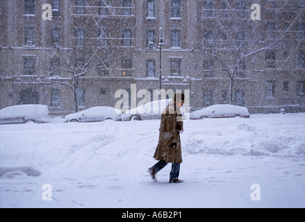 Winterwetter, ein Schneesturm in New York City. Geparkte Autos in Schneeverwehungen vergraben, kein Verkehr. Ein Mann, der allein auf der Straße in Upper manhattan läuft. USA Stockfoto