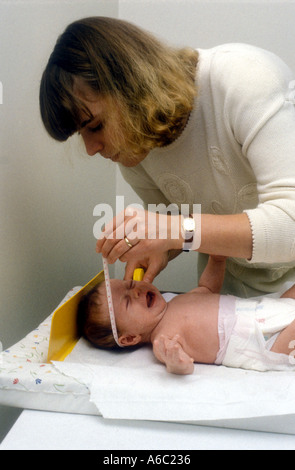 Gesundheit-Besucher, die den Kopf des Babys während der Routine-Check mit Abmessungen bis Stockfoto