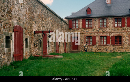 Ein Soldat kreuzt einen Innenhof im rekonstruierten 18. Jahrhundert Fort Louisbourg Cape Breton Nova Scotia Kanada Stockfoto