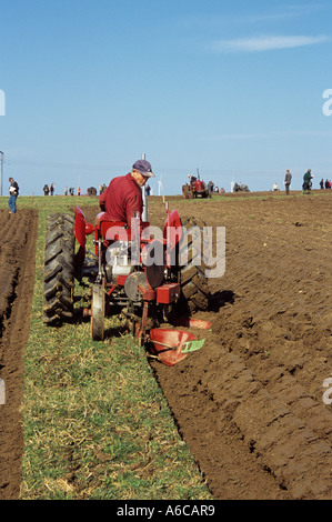 RHOSGOCH CEMAES ANGLESEY NORTH WALES UK März Vintage rot Traktor zieht einen Oldtimer Pflug im Wettbewerb im jährlichen match Stockfoto