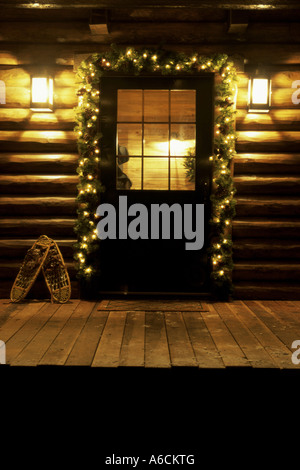 Weihnachtsdekorationen rund um ein Blockhaus-Tür Stockfoto