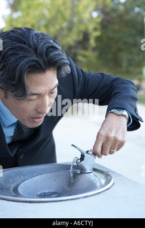 Geschäftsmann, trinken am Brunnen Stockfoto