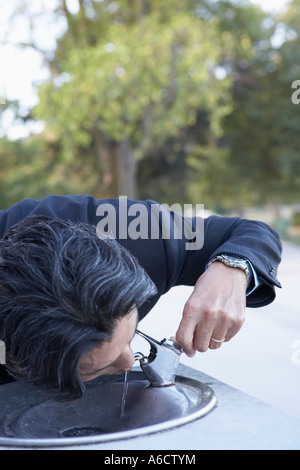 Geschäftsmann, trinken am Brunnen Stockfoto