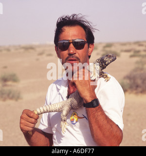 Tourist Guide packende live stacheligen tailed Eidechse gefangen von Hand in der Wüste in der Nähe von Abu Dhabi-Vereinigte Arabische Emirate-Nahost Stockfoto