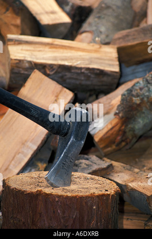Maul in Hackstock mit Haufen von Spaltebrennholz aufteilen Stockfoto