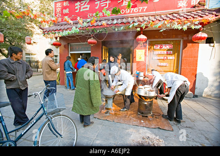 CHINA Peking winzig aber belebten Viertel Restaurant mit Köchen eingerichtet, auf dem Bürgersteig um Frühstück Knödel zubereiten Stockfoto