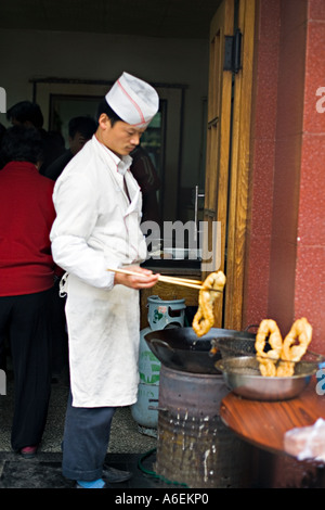 CHINA Peking winzig aber belebten Viertel Restaurant mit Köchen eingerichtet, auf dem Bürgersteig um Frühstück gebraten Teig zubereiten Stockfoto