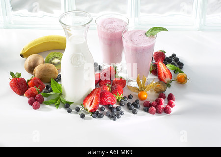 Milch-Botte mit zwei Gläser Erdbeer Milchshake, umgeben von Obst Stockfoto