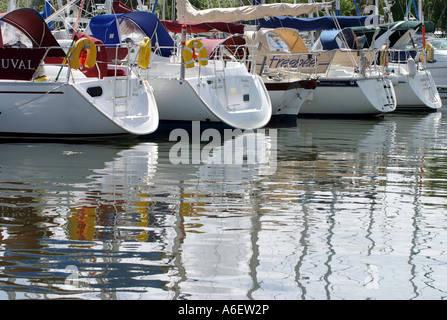 Ankern Yachten und ihre Spiegelungen im Wasser, Chichester Marina, Sussex, England Stockfoto