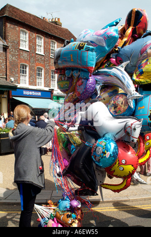 Straße Verkäufer hält eine Masse von Helium gefüllt Metallfolie Ballons. Stockfoto