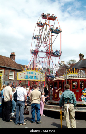 Riesenrad dreht sich hoch über der Masse zu einem kleinen Dorffest in Dorset Stockfoto