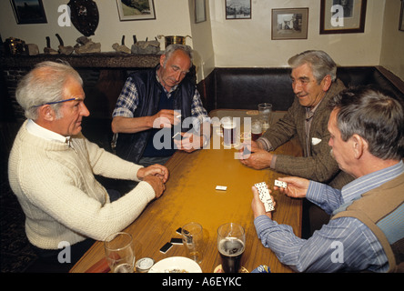 Vier Männer der 60er Jahre 70er Jahre genießen eine Dominospiel in einer Kneipe im Norden Englands in den 1980er Jahren. Stockfoto