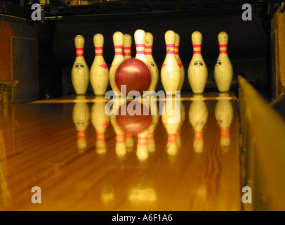 Zehn-Pin-Bowling, Bowling-Ball schnell nähert sich stehenden Pins am Ende einer Indoor-Bowling-Holzbahn, Bowling in einer Bowlingbahn Stockfoto