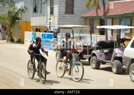 BELIZE San Pedro auf Ambergris Caye Schulkinder in Uniformen nach Hause für Mittagessen Fahrrad in die Stadt Straße Stockfoto