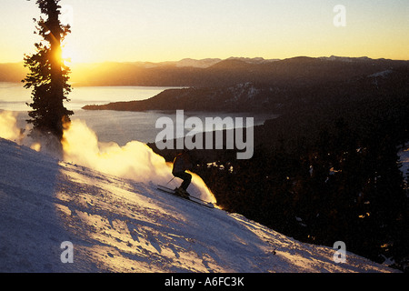 Ein Mann, Skifahren bei Sonnenuntergang am Diamond Peak über dem Lake Tahoe in Nevada Stockfoto