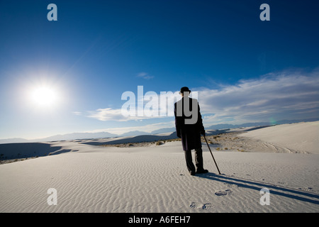Mann mit Mantel und Bowler Hut mit Blick auf weiße Sanddüne Wüste Stockfoto