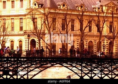Louvre Pont des Artes Paris Frankreich Passanten über die Pont des Artes Fußgängerbrücke über den Fluss seine Musée de Louvre Louv Stockfoto