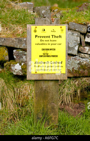 Zweisprachig Englisch Walisisch zu verhindern Diebstahl Zeichen auf einem Parkplatz in den Brecon Beacons National Park Powys South Wales UK Stockfoto