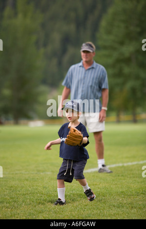 Junge Erwachsene suchen auf hinter ihm Baseball zu spielen Stockfoto