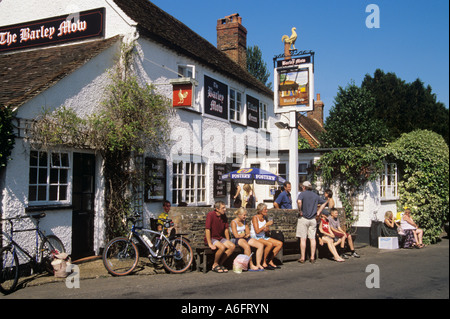 Die Gerste Mow Country Village Pub mit Menschen Kunden saß draußen an heißen sonnigen Sommertag Sonnenschein genießen. Tilford Surrey England Großbritannien Stockfoto