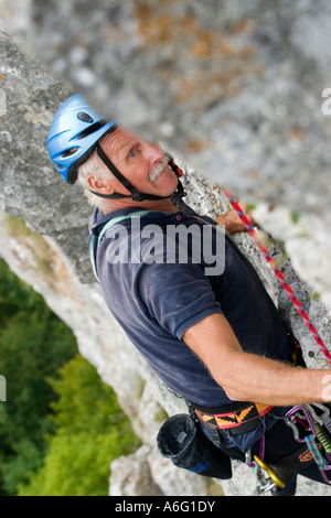 Senior woman Klettern in Kalkstein mit blauen Helm Donautal bei Sigmaringen schwäbischen Jura Deutschland Stockfoto