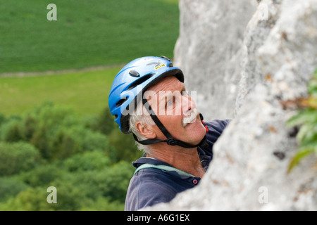 Senior woman Klettern in Kalkstein mit blauen Helm Donautal bei Sigmaringen schwäbischen Jura Deutschland Stockfoto