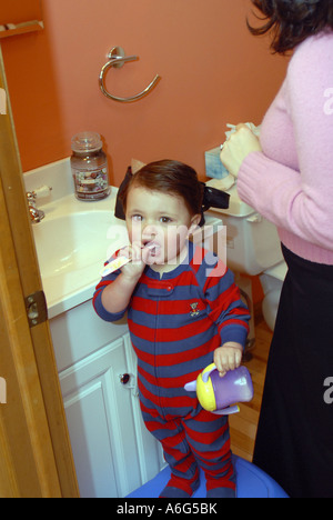 Hispanic 30 Jahre alte Mutter ist immer bereit für die Arbeit am Morgen während sechzehn 16 Monate alten Jungen Bürsten Zähne