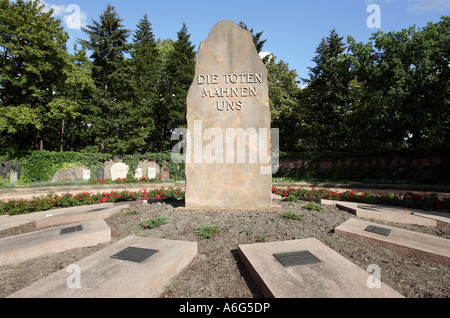 Inschrift: Die Toten erinnern uns auf einer Stele neben den Gräbern von Karl Liebknecht und Rosa Luxemburg, Zentralfriedhof in Berlin Stockfoto